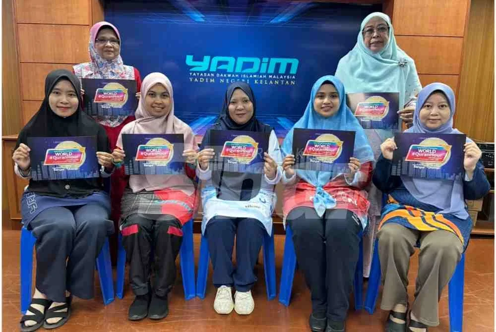 Yusnita (tengah) bersama kakitangan Yadim dan wakil PRNNK memegang risalah World #QuranHour.