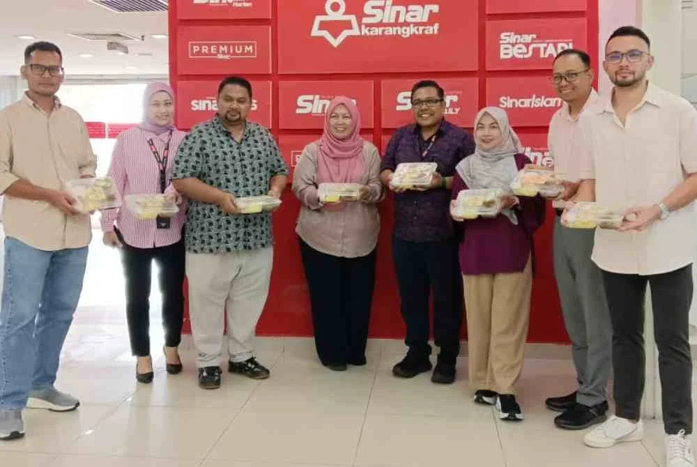 Mashitah (empat dari kiri) dan Zamri (empat dari kanan) bergambar bersama selepas penyerahan pek makanan sumbangan PLUS di Karangkraf, Shah Alam pada Rabu.