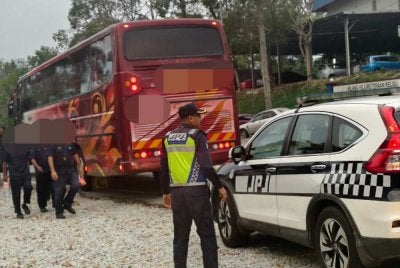 Penguat kuasa JPJ menahan sebuah bas yang membawa pekerja kilang.