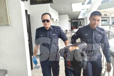 Tertuduh (tengah) mengaku bersalah di Mahkamah Majistret Ayer Keroh atas pertuduhan menceroboh Kem Terendak, pada Sabtu lalu.