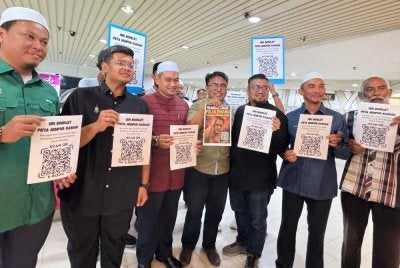 Chegubard (tiga dari kanan) melancarkan sebuah booklet yang mengandungi 14 mukasurat mengenai pendedahan berhubung isu berkenaan untuk rujukan umum melalui kod QR di Komtar pada Rabu.