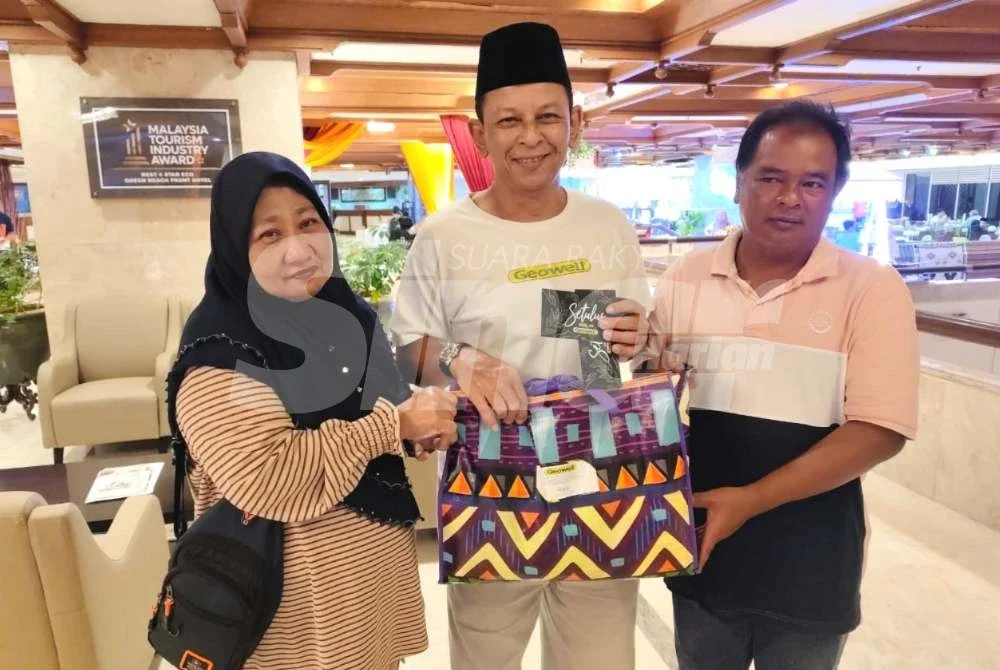 Kamal Afandi (tengah) menyerahkan sumbangan dan wang tunai bagi menceriakan pasangan suami isteri berkenaan sempena Ramadan dan sambutan Aidilfitri. Foto Sinar Harian