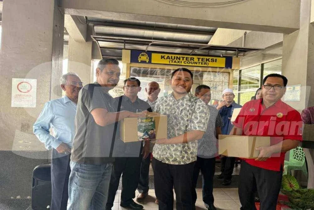 Mohd Ridhwan (tengah) menyampaikan foodbank kepada penerima sempena Ramadan.