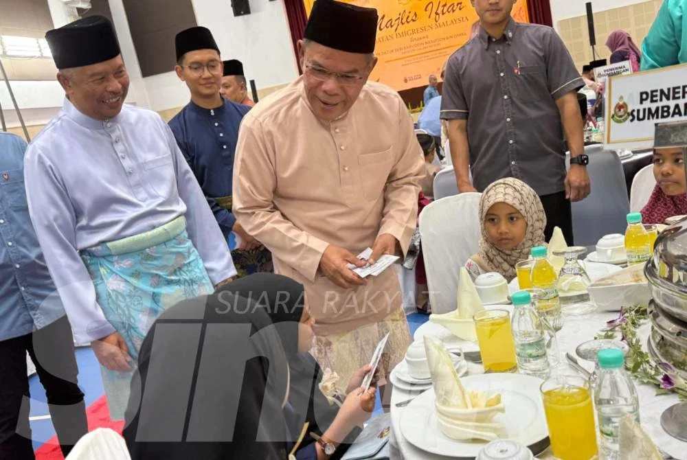 Saifuddin menyampaikan sumbangan kepada anak yatim pada majlis berkenaan.