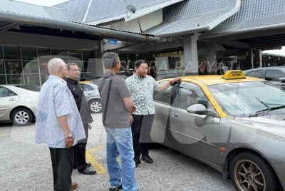 Mohd Ridhwan (kanan) meninjau operasi kereta sewa di Melaka Sentral. 