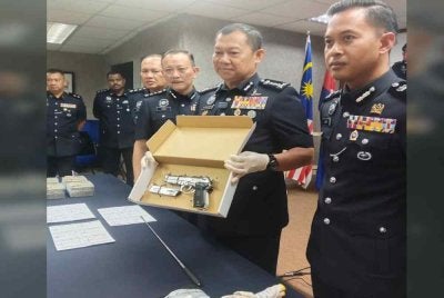 Ab Rahaman (dua dari kanan) menunjukkan pistol digunakan suspek dalam kes rompakan di Pasir Gudang.