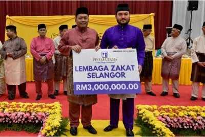 Tengku Amir (kanan) berkenan menerima serahan zakat perniagaan berjumlah RM3 juta daripada Zainudin Karjan pada Majlis Berbuka Puasa Raja Muda Selangor Bersama Rakyat dan Penyampaian Sumbangan Hari Raya 1447H di Masjid Raja Haji Fisabilillah, Cyberjaya pada Rabu.