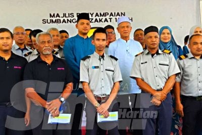 Che Ibrahim (belakang, tiga kanan) bersama pemandu-pemandu pada Majlis Penyampaian Sumbangan Zakat E-Mutiara di Kota Bharu pada Khamis.