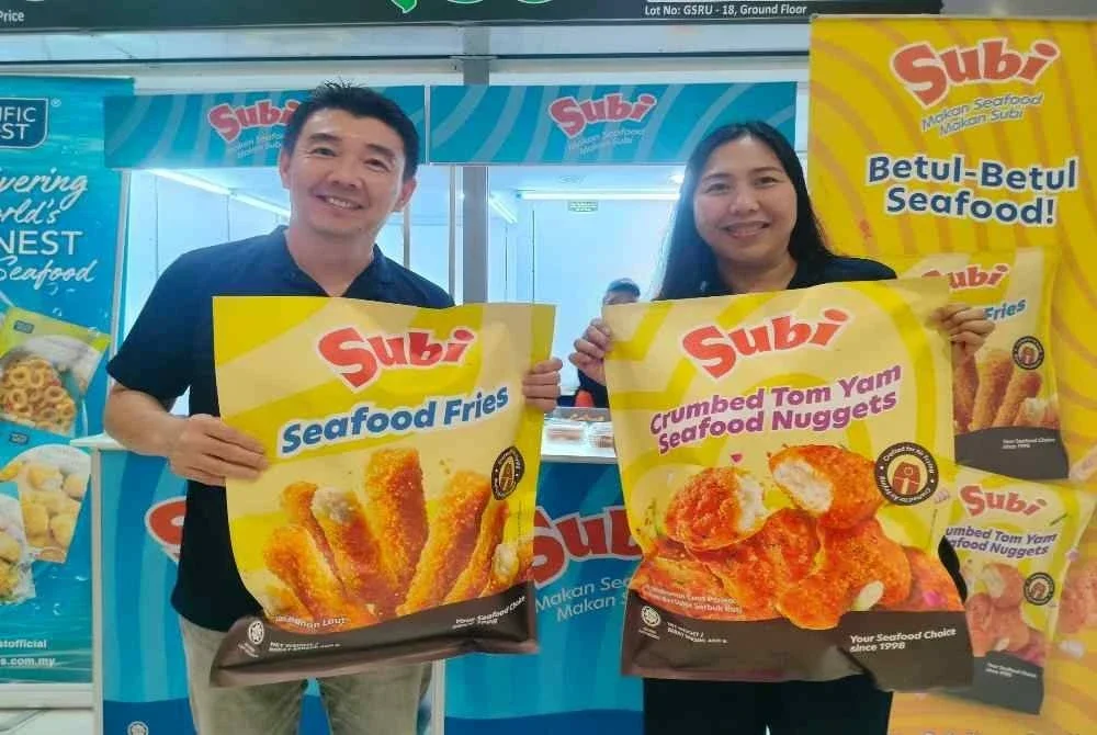 Kok Wah (kiri) menunjukkan produk dikeluarkan Sini ketika ditemui di Mydin Mall Meru Raya.