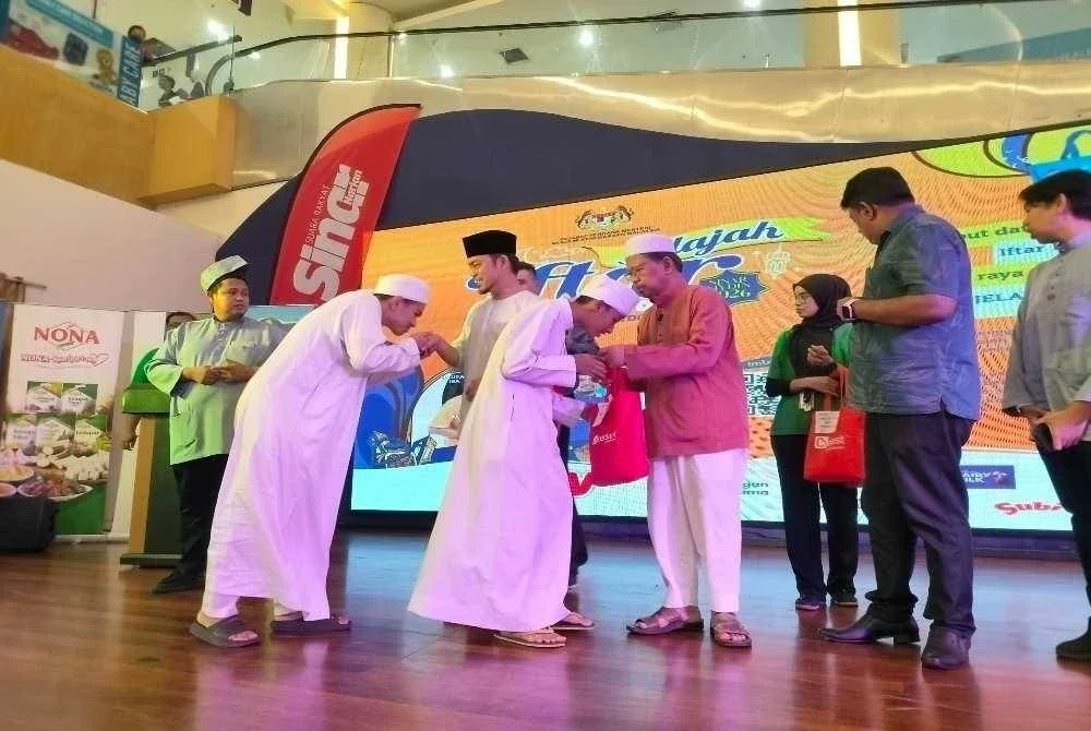 Asmuni (tengah) bersama Hafez (dua dari kiri) menyampaikan sumbangan Hari Raya Aidilfitri daripada Boost Bank kepada pelajar Maahad Tahfiz Miftahul Jannah, Buntong sempena Jelajah Iftar Sinar Mydin 2026 di Mydin Mall Meru Raya.