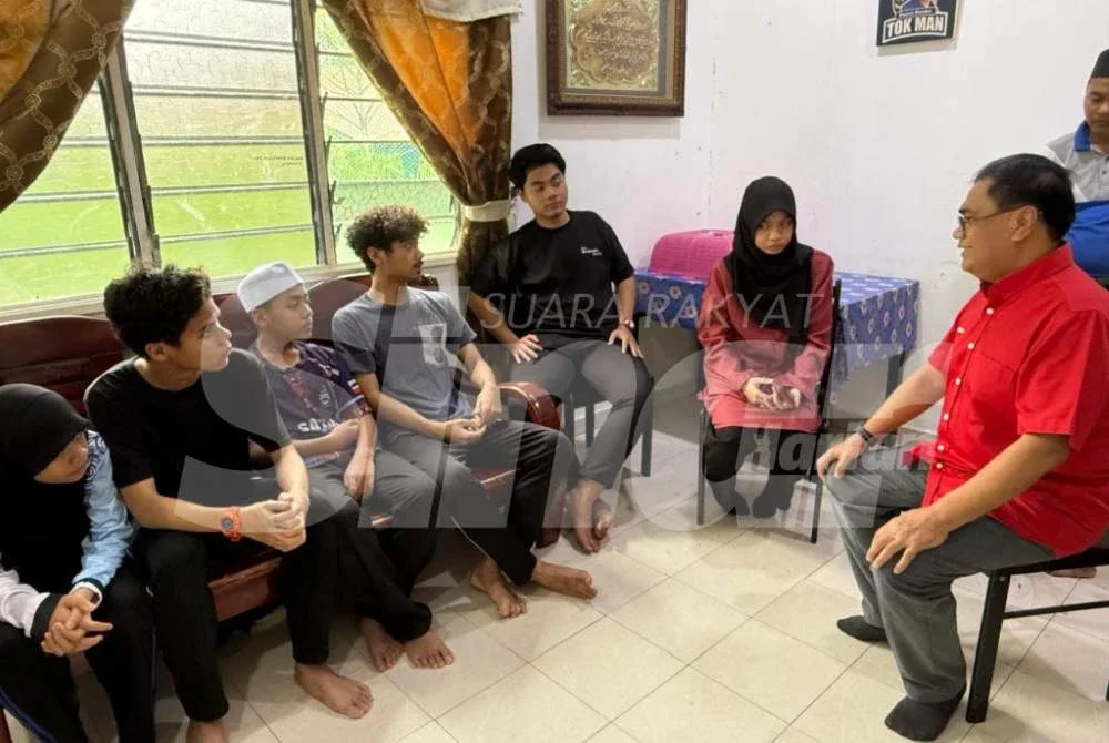 Azman (kanan) melawat enam beradik yatim piatu terbabit.