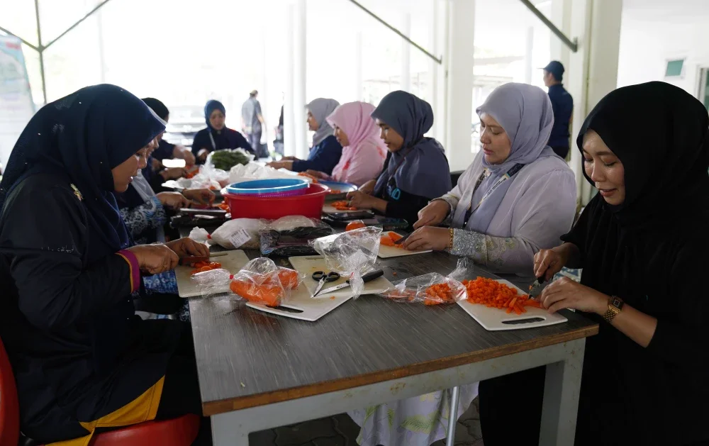 Staf MyDigital ID bergotong royong menyediakan juadah bubur lambuk pada program Iftar Rewang Pelajar MyDigital ID di Pusat Asasi Universiti Teknologi Mara (UiTM), Cawangan Selangor Kampus Dengkil, pada Khamis