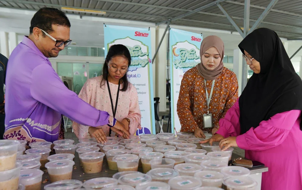 Pelajar royong menyediakan juadah bubur lambuk pada program Iftar Rewang Pelajar MyDigital ID di Pusat Asasi Universiti Teknologi Mara (UiTM), Cawangan Selangor Kampus Dengkil, pada Khamis.
