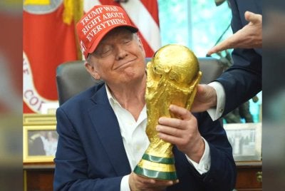 Donald Trump memegang trofi Piala Dunia. Foto Agensi