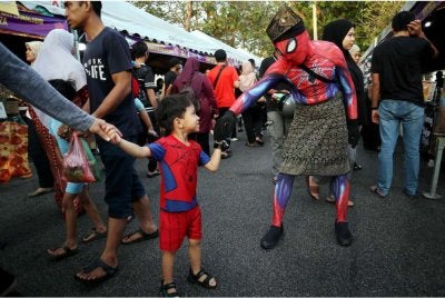 Jaafar Shah Mohd Ismail, 42, menghiburkan pengunjung dengan memakai kostum Spiderman di bazar Ramadan Jaya Gading, Kuantan. Foto Bernama