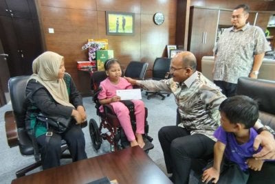 Mohd Salleh (dua kanan) turut menyampaikan sumbangan kepada Nur Umairah sebagai persediaan menyambut Aidilfitri bersama keluarganya.