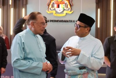 Anwar (kiri) berbincang bersama Ketua Setiausaha Negara Tan Sri Shamsul Azri abu Bakar pada Program Ihya Ramadan di JPA pada Jumaat. Foto Bernama