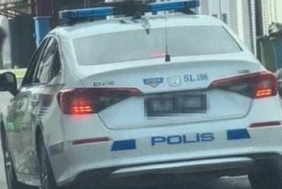 Tangkap layar rakaman video tular memaparkan sebuah MPV polis berhenti untuk mengambil bungkusan di sebuah restoran mamak.