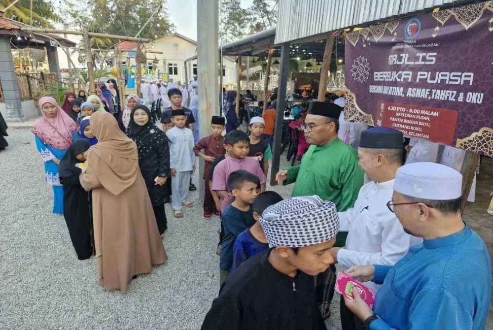 Mustafa (baju hijau) dan pimpinan PSKK menyantuni anak yatim, pelajar tahfiz dan OKU yang hadir.