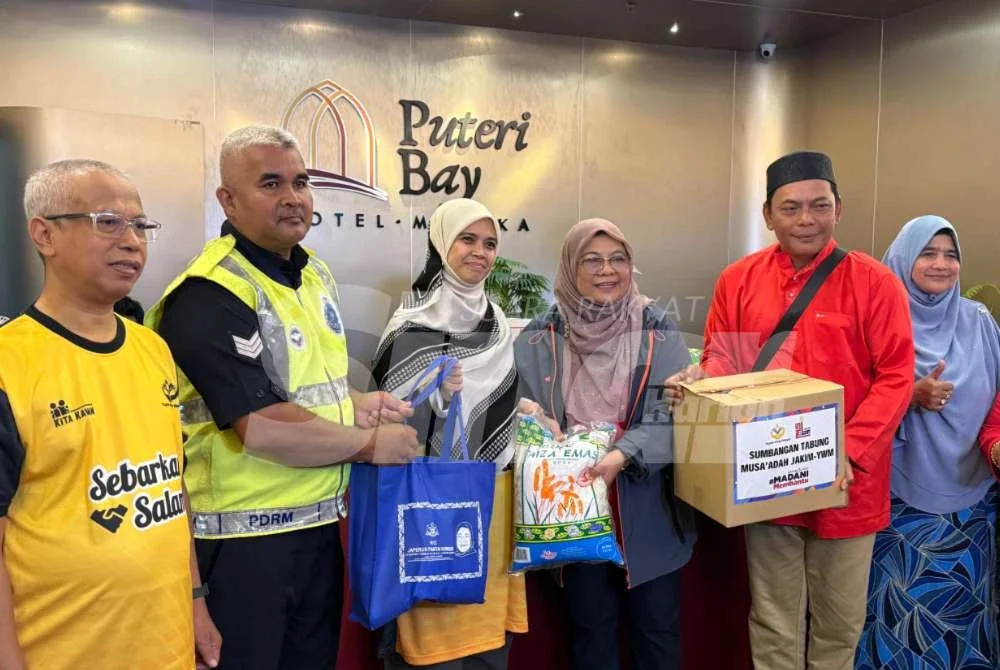 Marhamah (tiga dari kiri) menyampaikan sumbangan kepada pasukan keselamatan negara.
