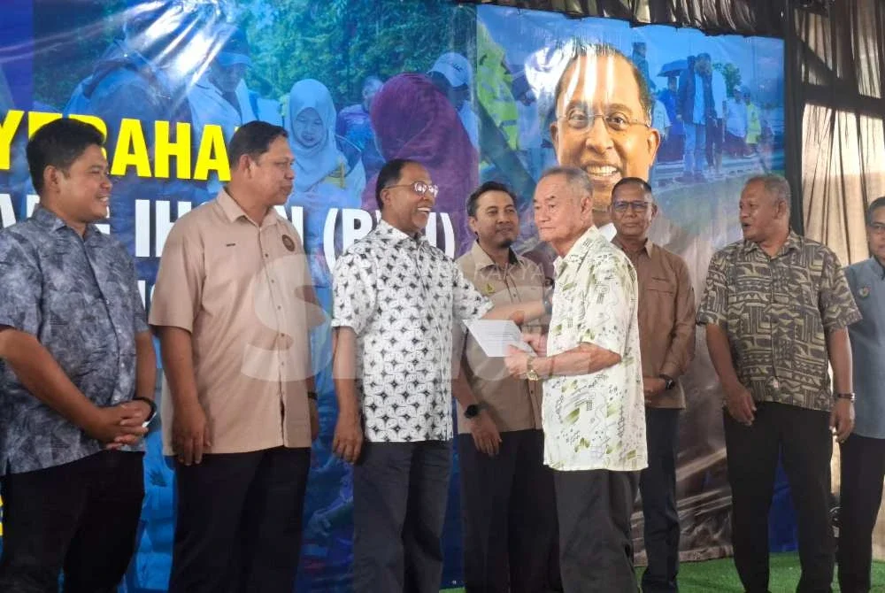 Zambry (tiga dari kiri) menyempurnakan penyerahan Bantuan Wang Ihsan (BWI) Daerah Manjung kepada 377 penerima yang terjejas akibat bencana banjir tahun lalu pada Sabtu.