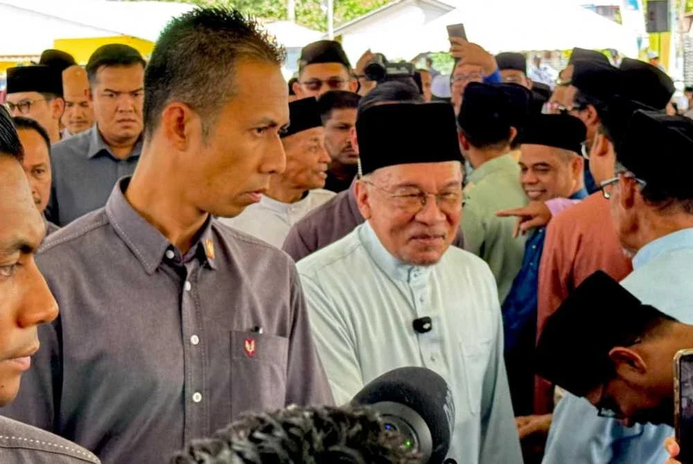 Anwar (tengah) bersalaman dengan orang ramai yang menghadiri Majlis Perasmian Masjid Mengkuang Titi di Permatang Pauh pada Sabtu.