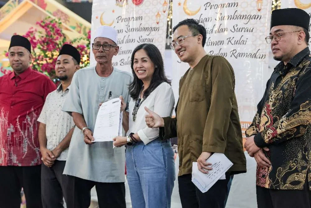 Nie Ching (tiga dari kanan) menyampaikan sumbangan kepada wakil masjid pada Program Serahan Sumbangan Masjid dan Surau Parlimen Kulai sempena bulan Ramadan di Kulai pada Sabtu. Foto: Bernama