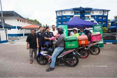 Ketua Bahagian Jabatan Pencegahan Jenayah dan Keselamatan Komuniti (JPJKK) IPD Seri Alam, Asisten Superintenden Mat Nawi Ab Rahman (tiga dari kiri) bersama Abdul Hakim mengagihkan pek berbuka puasa kepada penghantar p-hailing di Balai Polis Johor Jaya petang Jumaat.