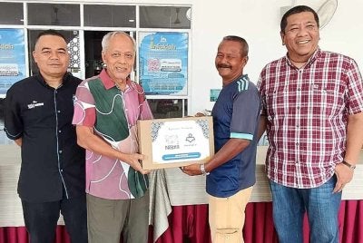 Muhammad Nasir (dua dari kiri) bersama Nik Justin (kanan) dan Yuslizan menyampaikan sumbangan kepada salah seorang penerima pada majlis yang berlangsung di Masjid At-Taqwa, Durian Burung di Kuala Terengganu.