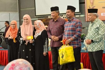Mohamad(tiga dari kanan) menyampaikan sumbangan kepada Ahli Dewan Undangan Negeri BN di majlis Khatam al-Quran NSWO/Pekerti.