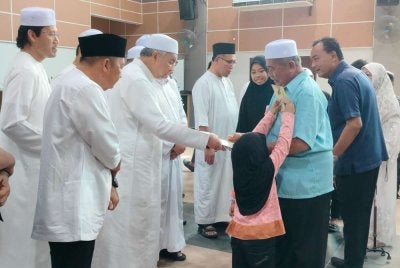 Ahmad Zahid (tiga dari kiri) menyampaikan sumbangan kepada penerima sempena Program Ihya’ Ramadan Al-Mubarak 1447H/2026M DUN Rungkup, Parlimen Kawasan Bagan Datuk di Dewan Dato’ Lope Hashim di sini pada Sabtu.