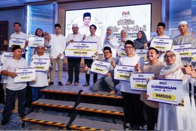 Adam Adli (tengah) bergambar kenangan bersama penerima sumbangan Akaun SSPN Prime pada Majlis Iftar Perdana bersama Media Melaka di sebuah hotel dekat Banda Hilir pada Sabtu. Foto: Bernama