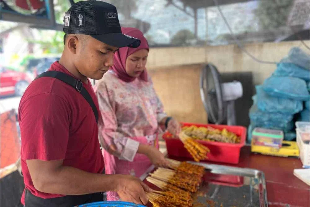 Mohamad Nasrul Iman membantu isterinya menjual perut ayam percik.
