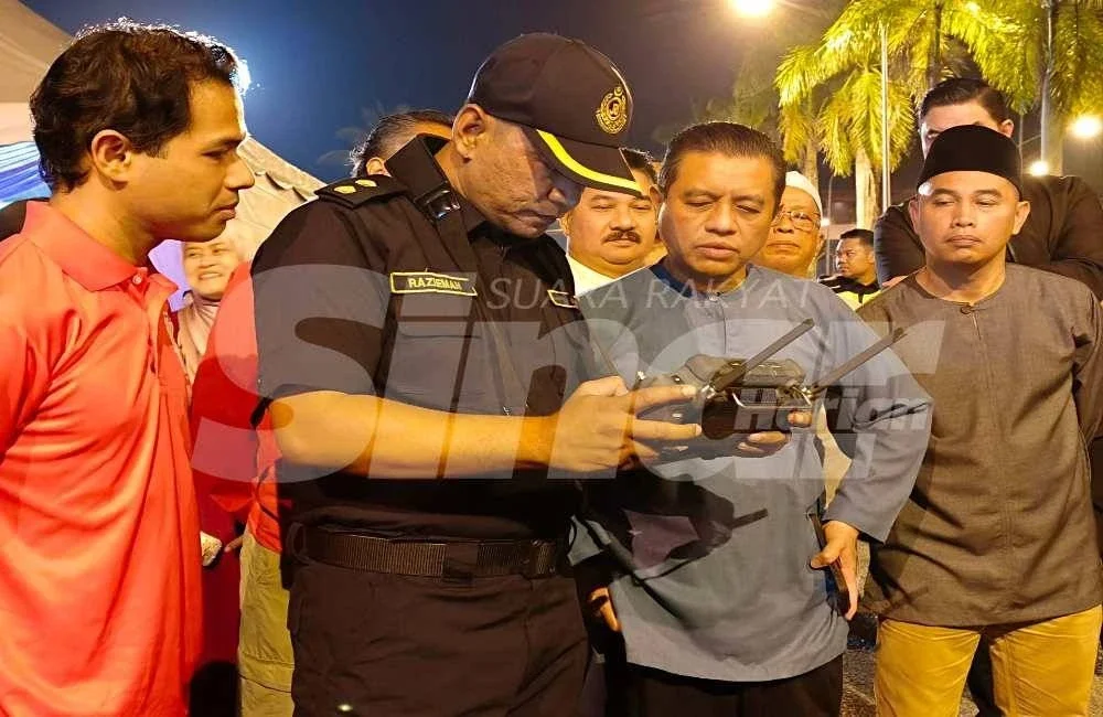 Aedy Fadly (dua dari kanan) melihat pegawai penguat kuasa mengendalikan dron bagi memantau keadaan lalu lintas pada Majlis Penerapan Nilai-nilai Murni dan Singgah Sahur di Stesen Penguat Kuasa (SPK) Labok, Machang pada Ahad. 