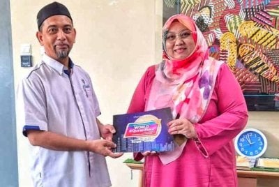 Md Abdu (kiri) menyampaikan bahan promosi kepada Ketua Perkhidmatan Perpustakaan dan Literasi PPAP, Maria Hamzah sebagai simbolik jalinan kerjasama menjayakan program WQH dijadualkan berlangsung di Masjid Sultan Ahmad Shah di Taman Sungai Isap pada 11 Mac ini.