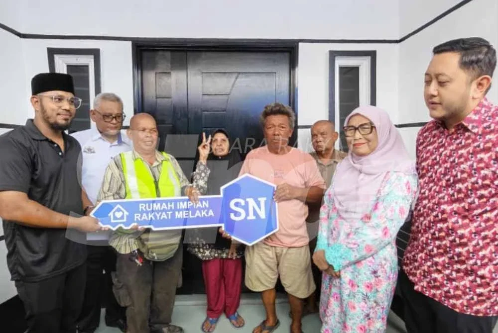 Mohd Ridhwan (kanan) dan Kalsom (dua dari kanan) menyaksikan penyerahan kunci kepada enam beradik lembam terbabit.