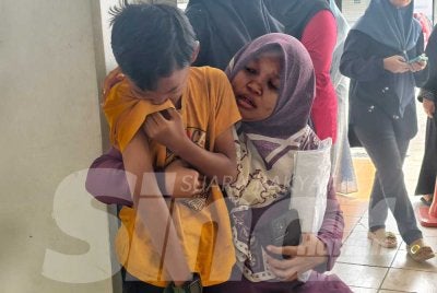 Norasiyah menenangkan anaknya yang menangis di Unit Perubatan Forensik Hospital Rembau