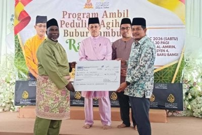 ABDUL RASHID (kiri) menyerahkan replika cek zakat wakalah berjumlah RM75,000 kepada Surau Al-Amirin. 