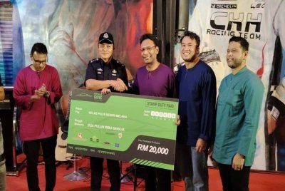 Dzulkhairi (dua dari kiri) mewakili polis Melaka menerima sumbangan sempena Singgah Sahur yang menghimpunkan Supercar Gang dan motosikal berkuasa tinggi DOCM di Kilang Makan di sini.