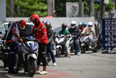 Penunggang motosikal beratur bagi mengisi minyak di stesen Quezon City, Metro Manila. Foto: AFP