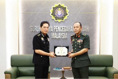 Malek (kanan) menyampaikan cenderamata kepada Azam ketika kunjungan hormatnya di Ibu Pejabat SPRM Putrajaya pada Isnin. - Foto: SPRM
