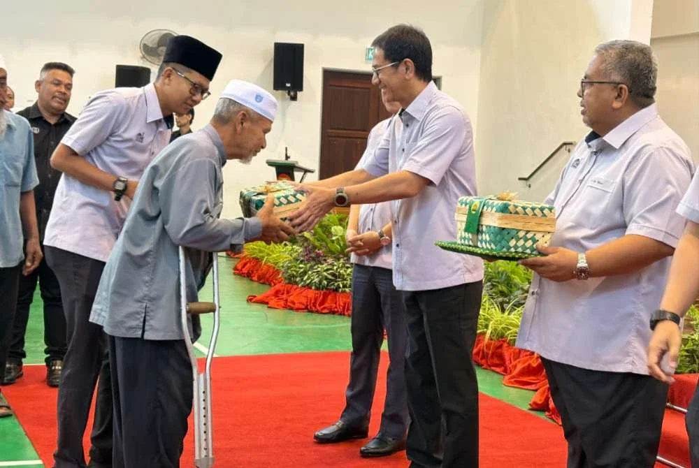 Tengku Sarafudin Badlishah (dua dari kanan) berkenan turun padang ke Dewan Serbaguna, Pejabat Daerah Pokok Sena bagi menyempurnakan sumbangan kepada 200 penerima terpilih pada Isnin.