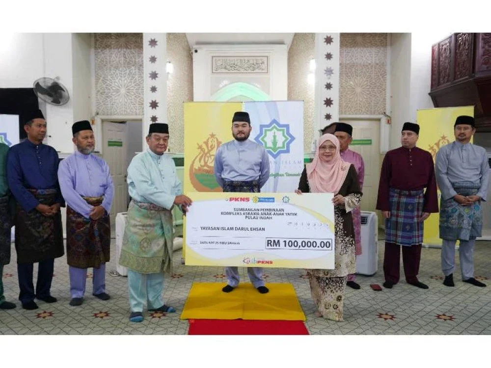 Tengku Amir Shah berkenan menyaksikan Sapna (kanan) menyerahkan simbolik cek kepada Mazlan (kiri) di Masjid Kampung Raja Uda, Klang.
