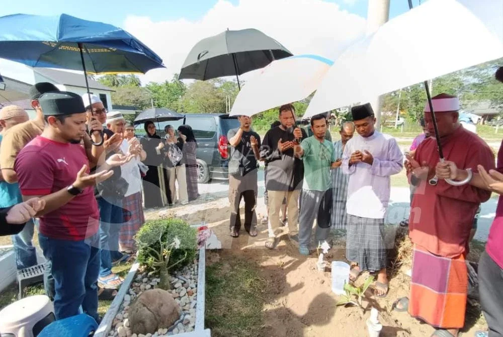 Mohd Syafaeez (dua dari kanan) ketika pengebumian anaknya, Hayl Haarith pada Selasa.