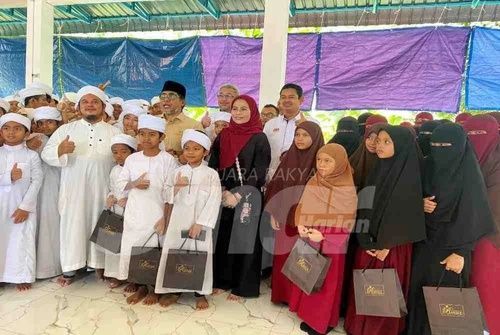 Noraini (tengah) bersama para pelajar Maahad Tahfiz Al-Quran Al Iman di Kampung Buloh Poh, Kota Bharu pada Selasa.