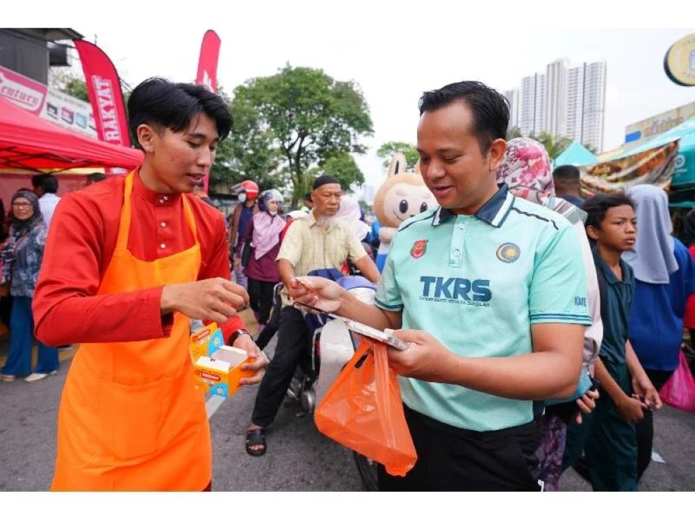 Petugas menerangkan produk Redoxon kepada salah seorang pengunjung bazar. 
