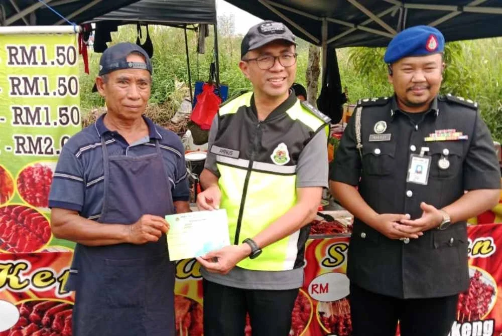Khairrul Aminus (tengah) beramah mesra bersama peniaga ketika program inspektorat bazar Ramadan Rimbayu di kawasan Jalan Kebun pada Isnin.