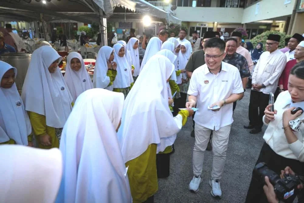 Kah Woh menyampaikan sumbangan duit raya kepada pelajar ketika hadir ke Program Jaulah Ramadan Kementerian Pendidikan di Sekolah Agama Bantuan Kerajaan Maahad Al Tarbiah Al Islamiah pada Selasa. Foto Bernama