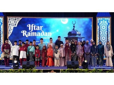 Izham (barisan kedua,lima dari kiri) dan Mahmud (barisan kedua, empat dari kiri) bergambar bersama penerima pada Program Iftar Ramadan Kasih PKNS di Pusat Konvensyen Shah Alam di sini pada Jumaat. 
