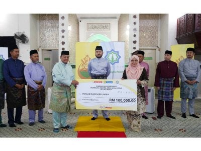 Tengku Amir Shah berkenan menyaksikan Sapna (kanan) menyerahkan simbolik cek kepada Mazlan (kiri) di Masjid Kampung Raja Uda, Klang.